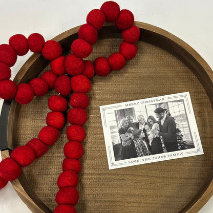 Red felt ornament on a wooden tray with a Christmas card underneath