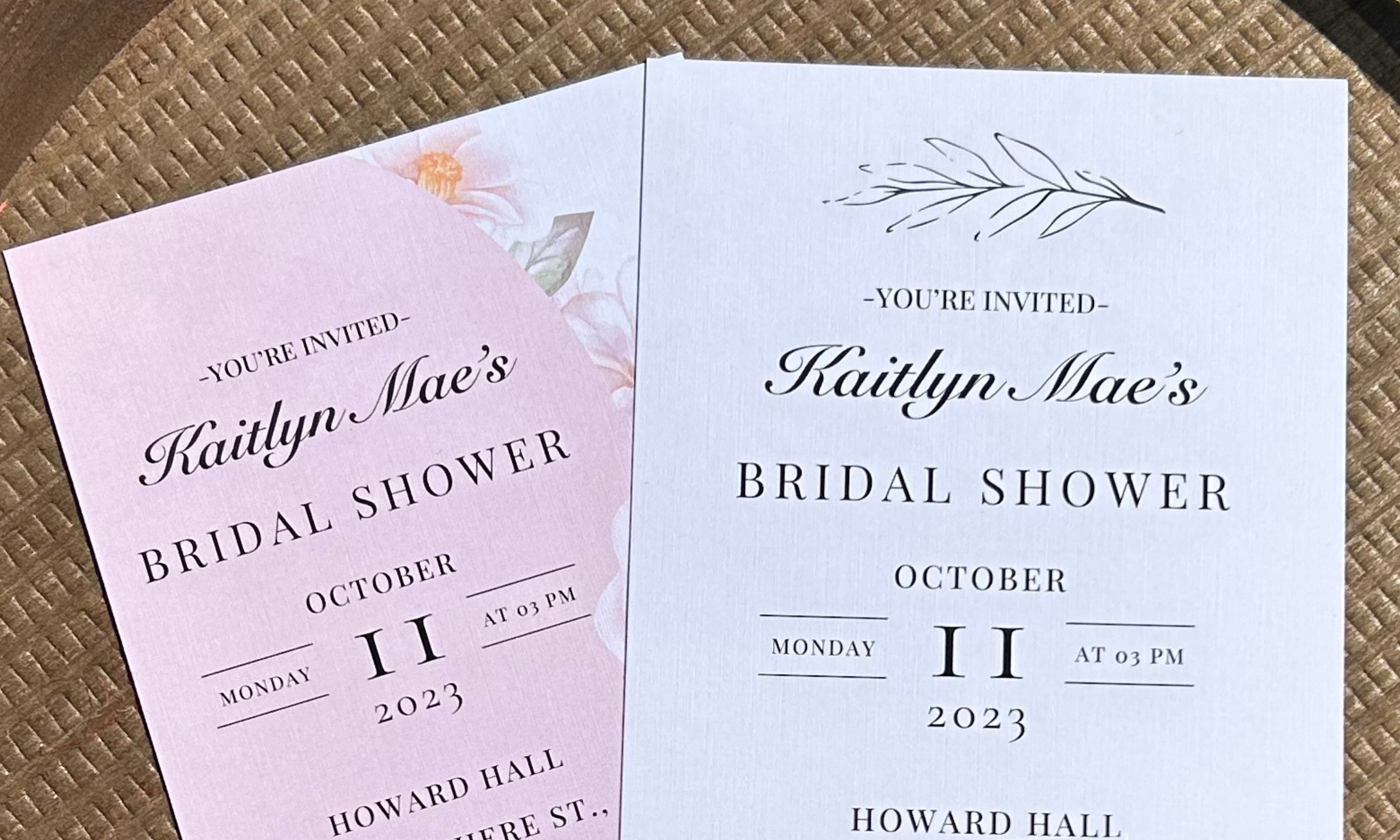 Two bridal shower invitations on a textured surface.
