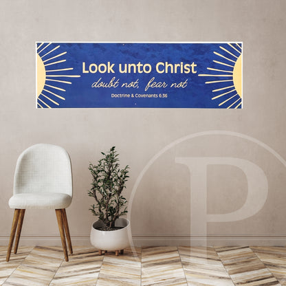 Decorative lds youth banner with 2025 yw/ym theme on a wall above a chair and plant.