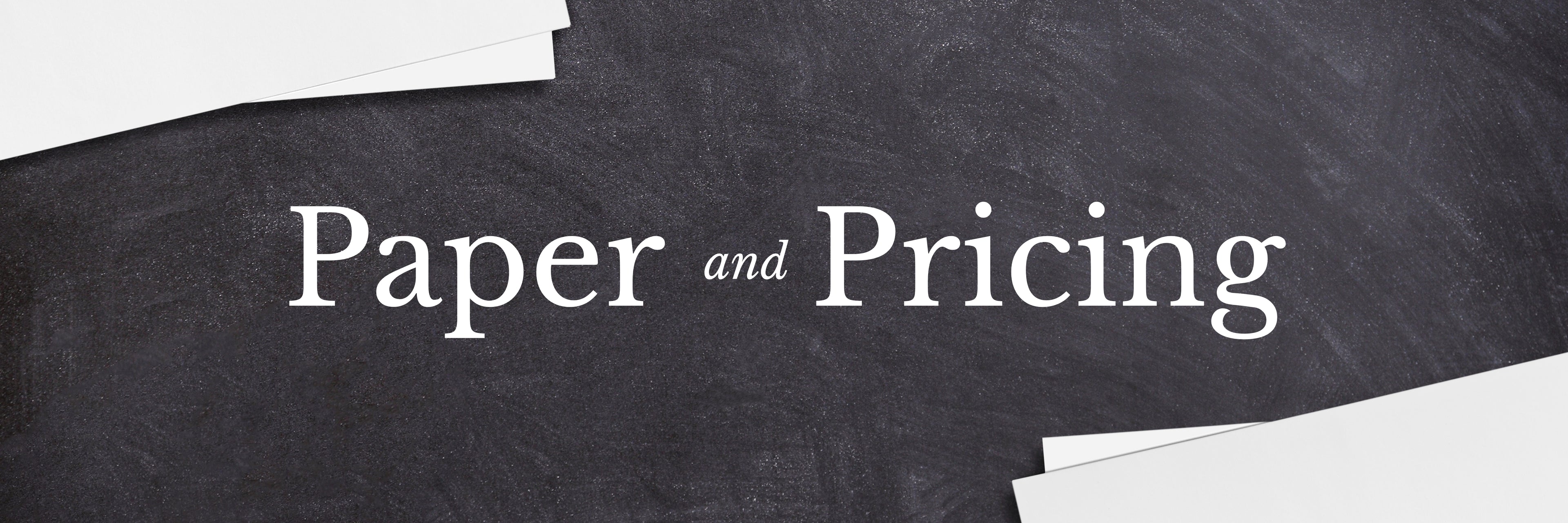 Text 'Paper and Pricing' on a black surface with white paper.