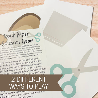 Rock Paper Scissors Game printed on a sheet of paper, shown on a light wood surface with a brown banner overlay reading '2 DIFFERENT WAYS TO PLAY'.