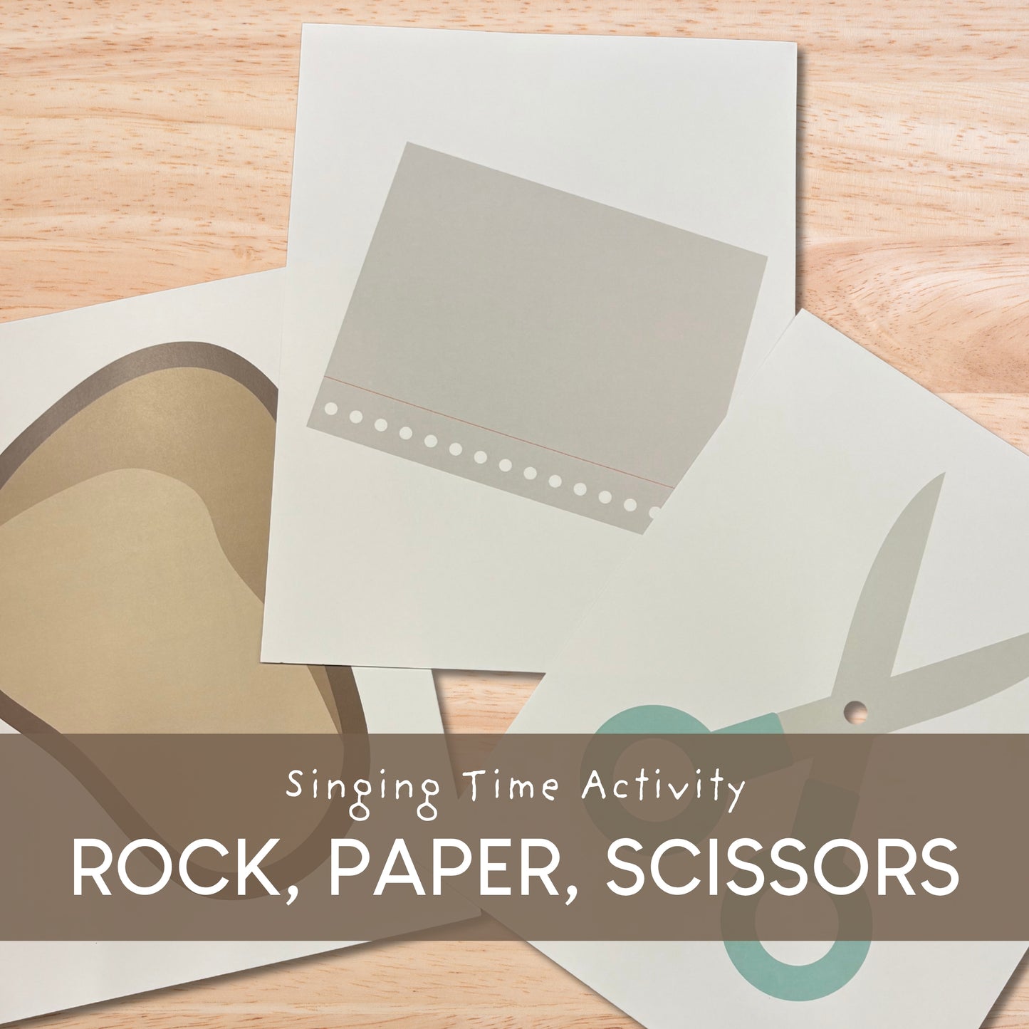Singing Time Activity Rock, Paper, Scissors game cards laid out on a light wood surface, with a brown banner across the bottom reading 'Singing Time Activity ROCK, PAPER, SCISSORS'.