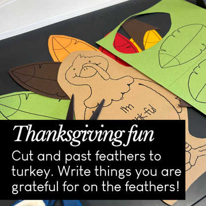 Thanksgiving craft activity with feathers and a turkey cutout on a table.