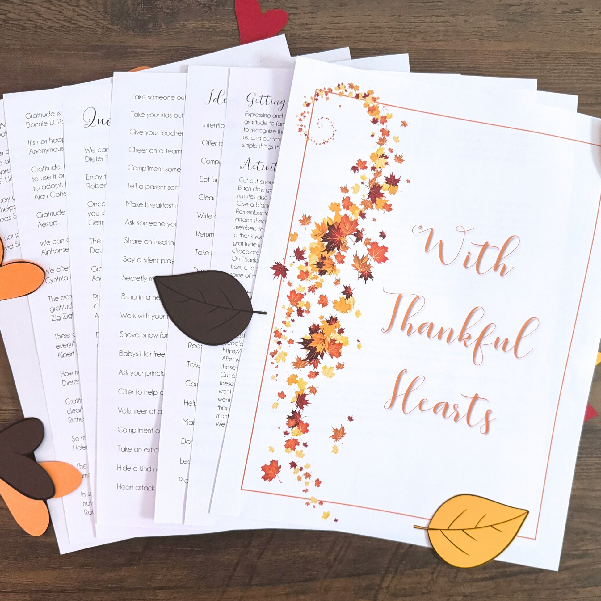 Thankful hearts printables with autumn leaves on a wooden surface